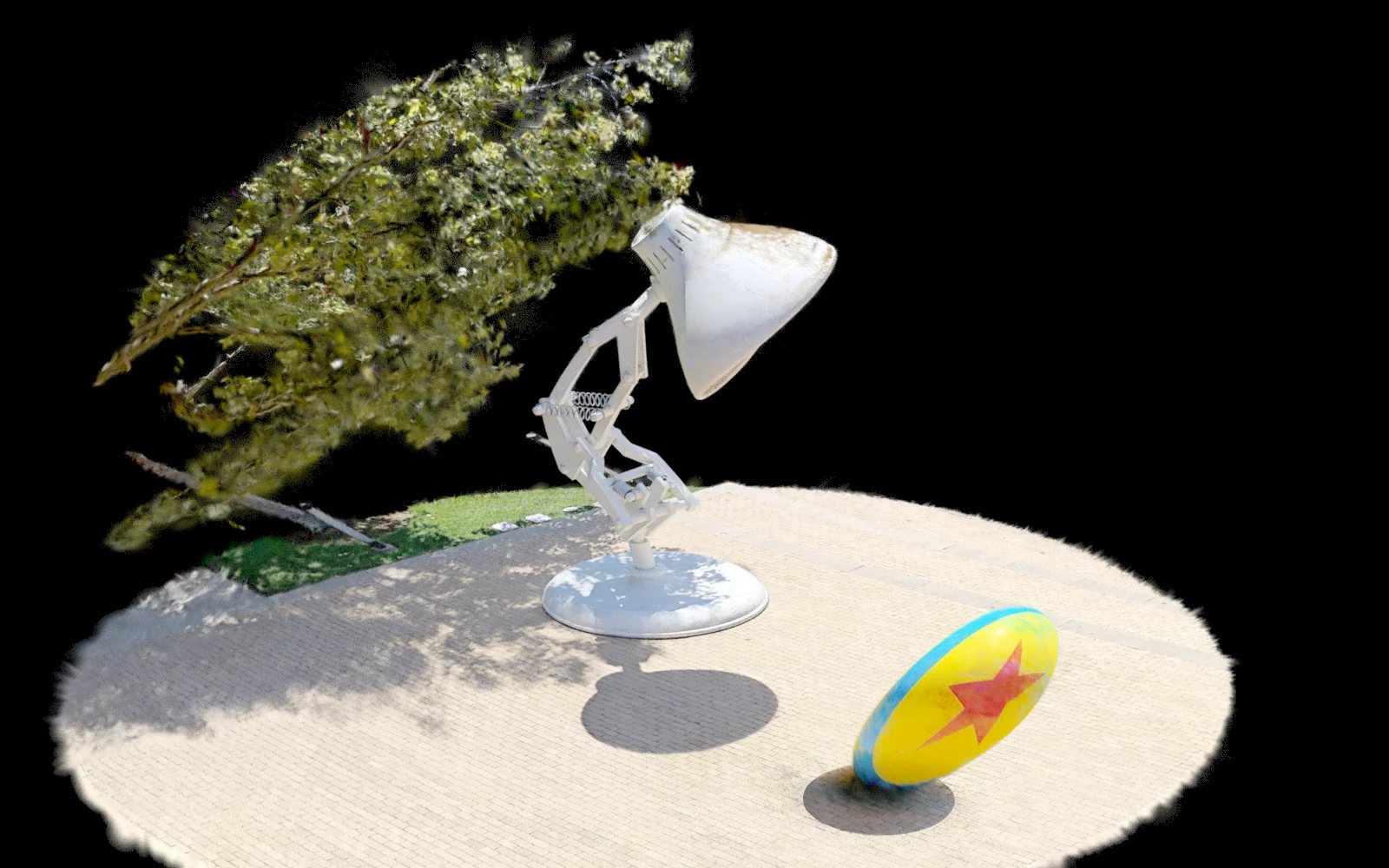 A Gaussian-splat render of Pixar's Luxo lamp statue and the yellow ball with a blue stripe and red star, on a circular patch of pale paving, with a tree behind them. The scene is cropped to a disc and floats on black.